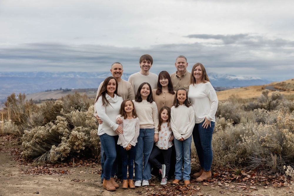 Family group photo session captured in a natural desert setting with sagebrush and mountains.