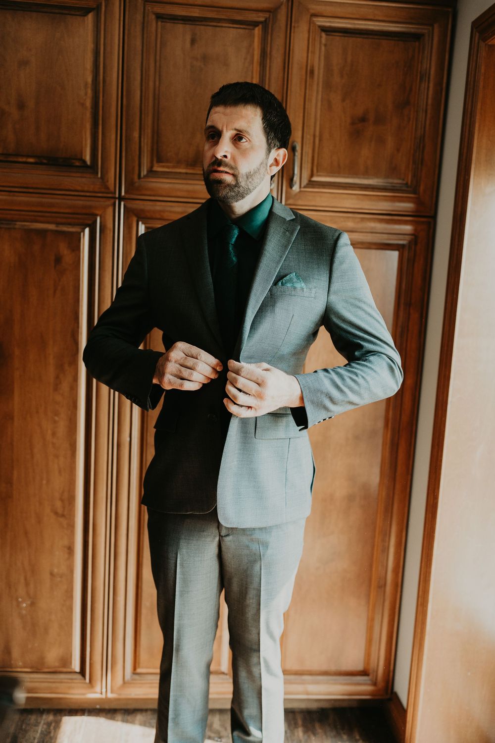 groom fastening his suit jacket