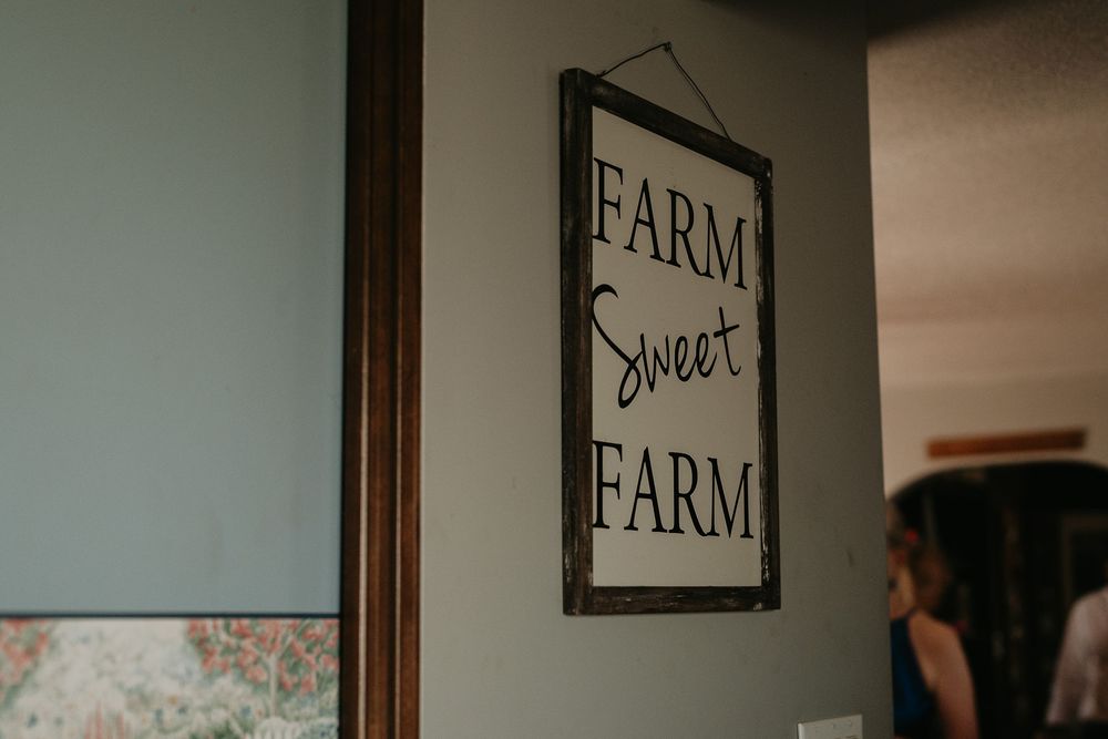 photo in an old farmhouse of a picture on the wall that says "Farm Sweet Farm"