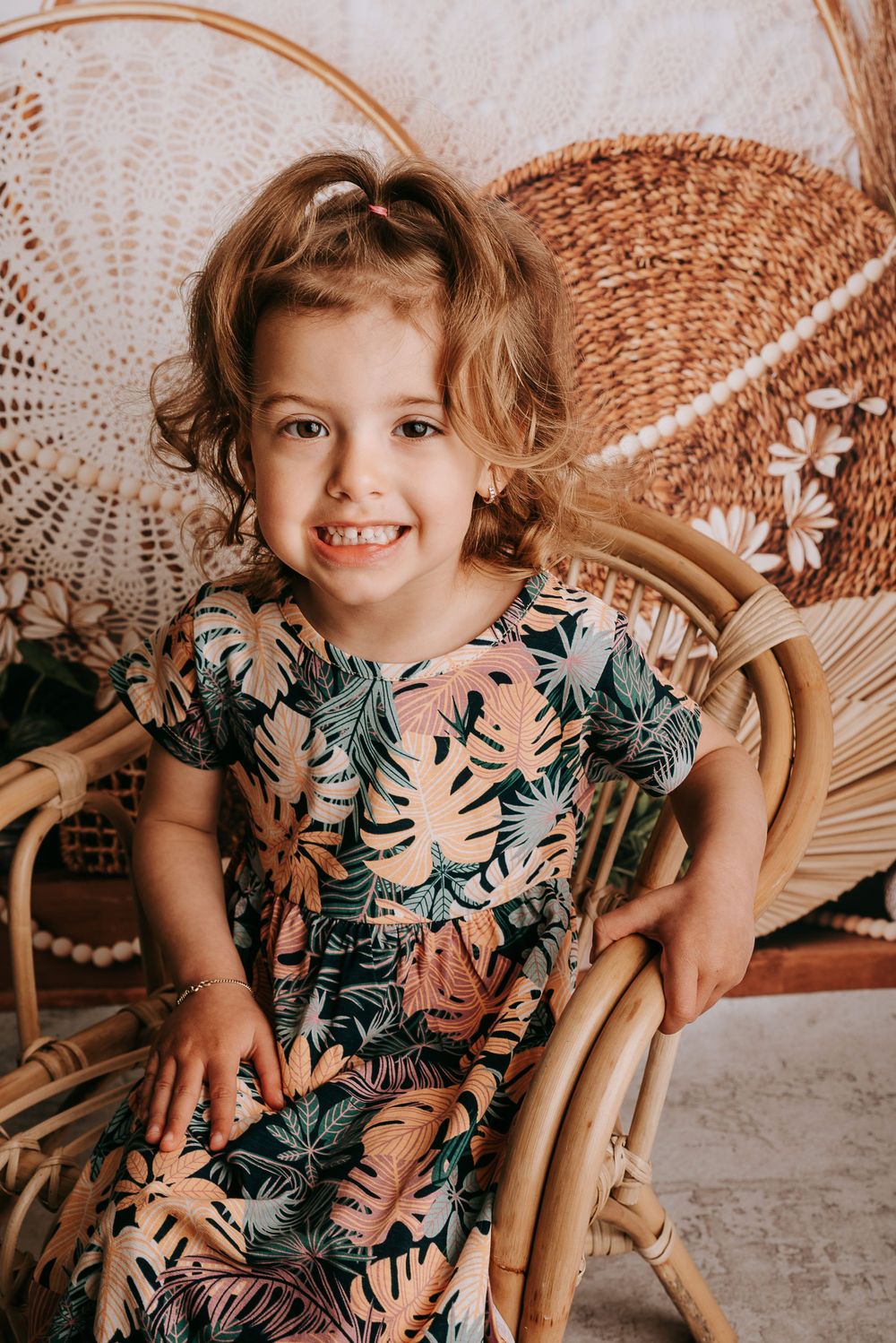 Bohemian styled setting with wicker chair and tropical print details.