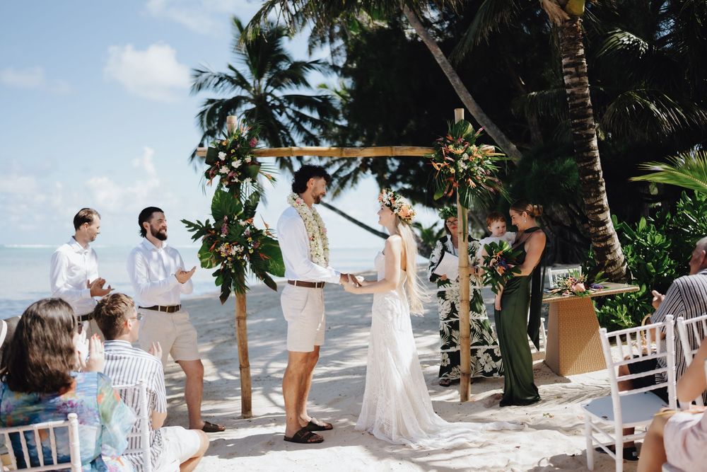 Panoramic collage of a romantic beach wedding ceremony with white decor and tropical palm trees by the ocean.
