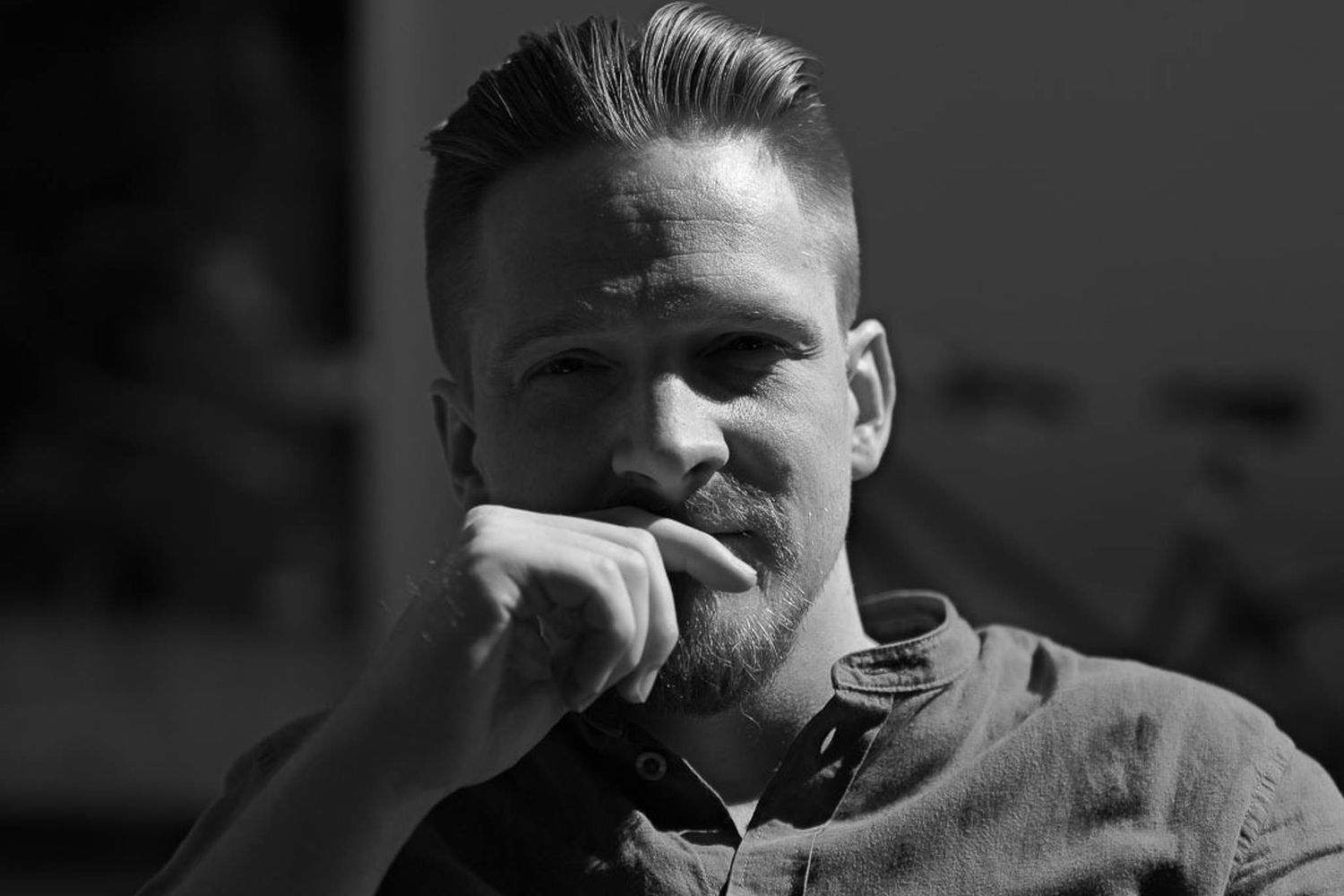 Black and white portrait with dramatic side lighting and strong shadows.