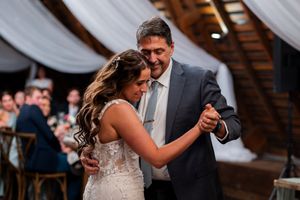 Wedding guests dancing together under draped fabric ceiling at an evening reception.