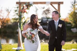 A couple shares a romantic moment together during their outdoor autumn wedding ceremony.