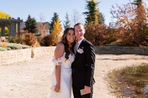 A joyful couple shares a candid moment together during their autumn wedding photoshoot.