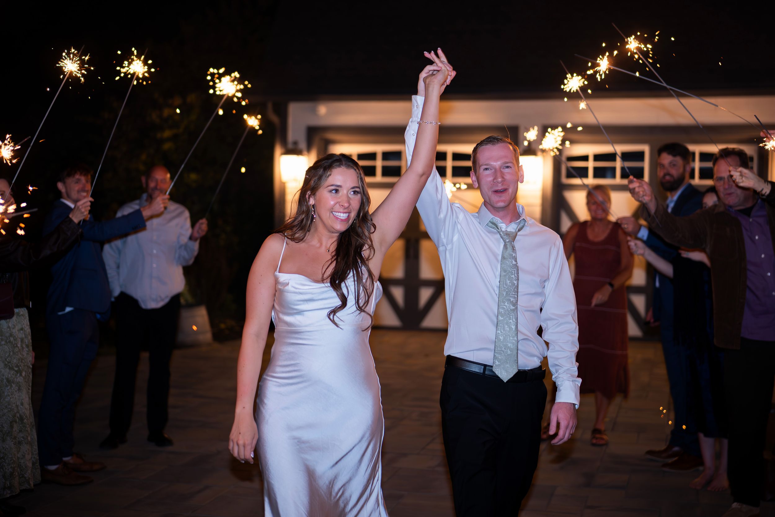 Wedding guests form a line dance on the dance floor during an evening reception celebration.