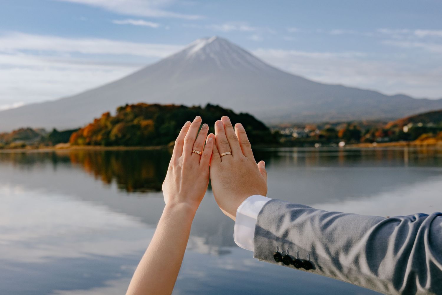 A series of scenic photos showing Mount Fuji reflected in a calm lake during different seasons and lighting conditions.
