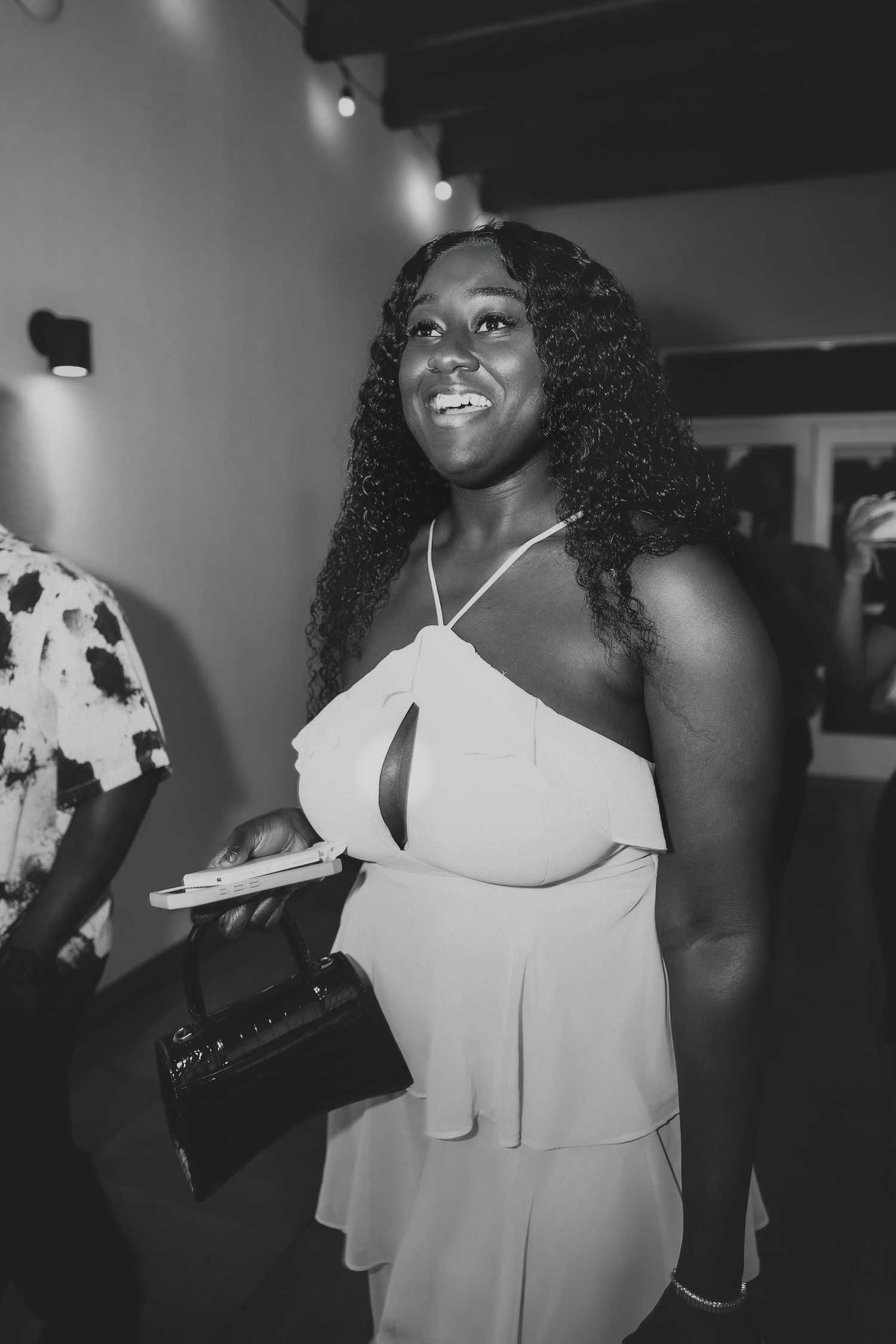 A series of black and white photos showing someone in a white sleeveless dress posing expressively against a dark background.