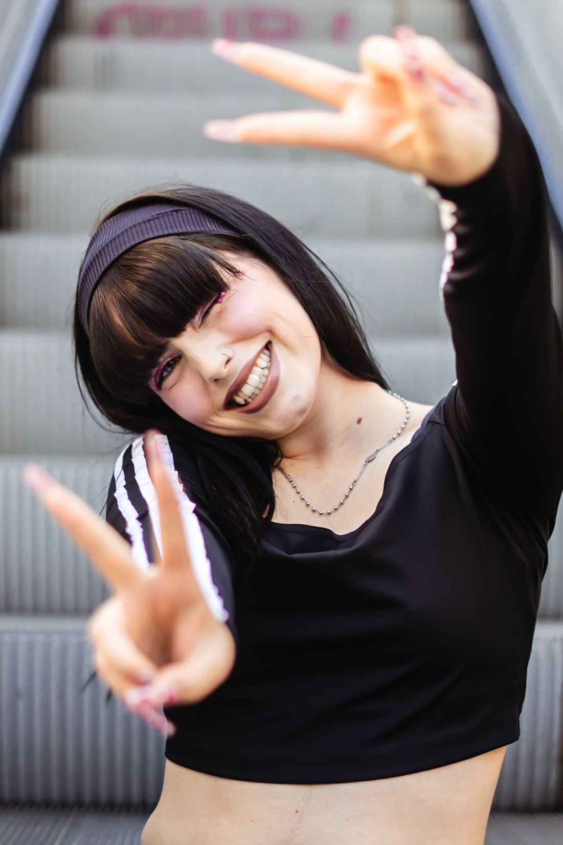A person in a black top dances energetically in a sequence of five dynamic poses against a light background.