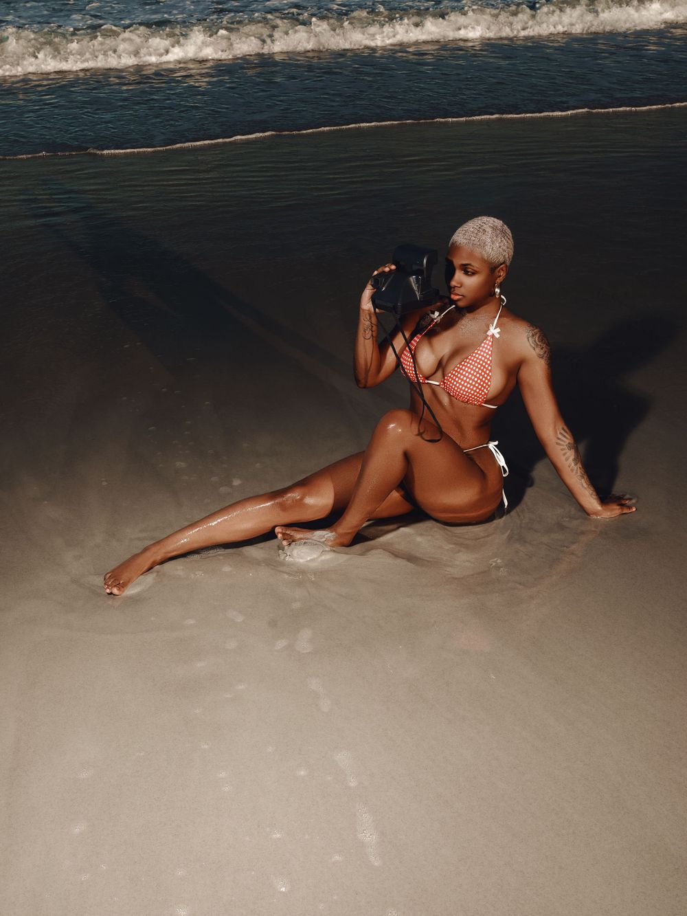 A figure in a swimsuit poses gracefully on a sandy beach at sunset creating an artistic silhouette series.