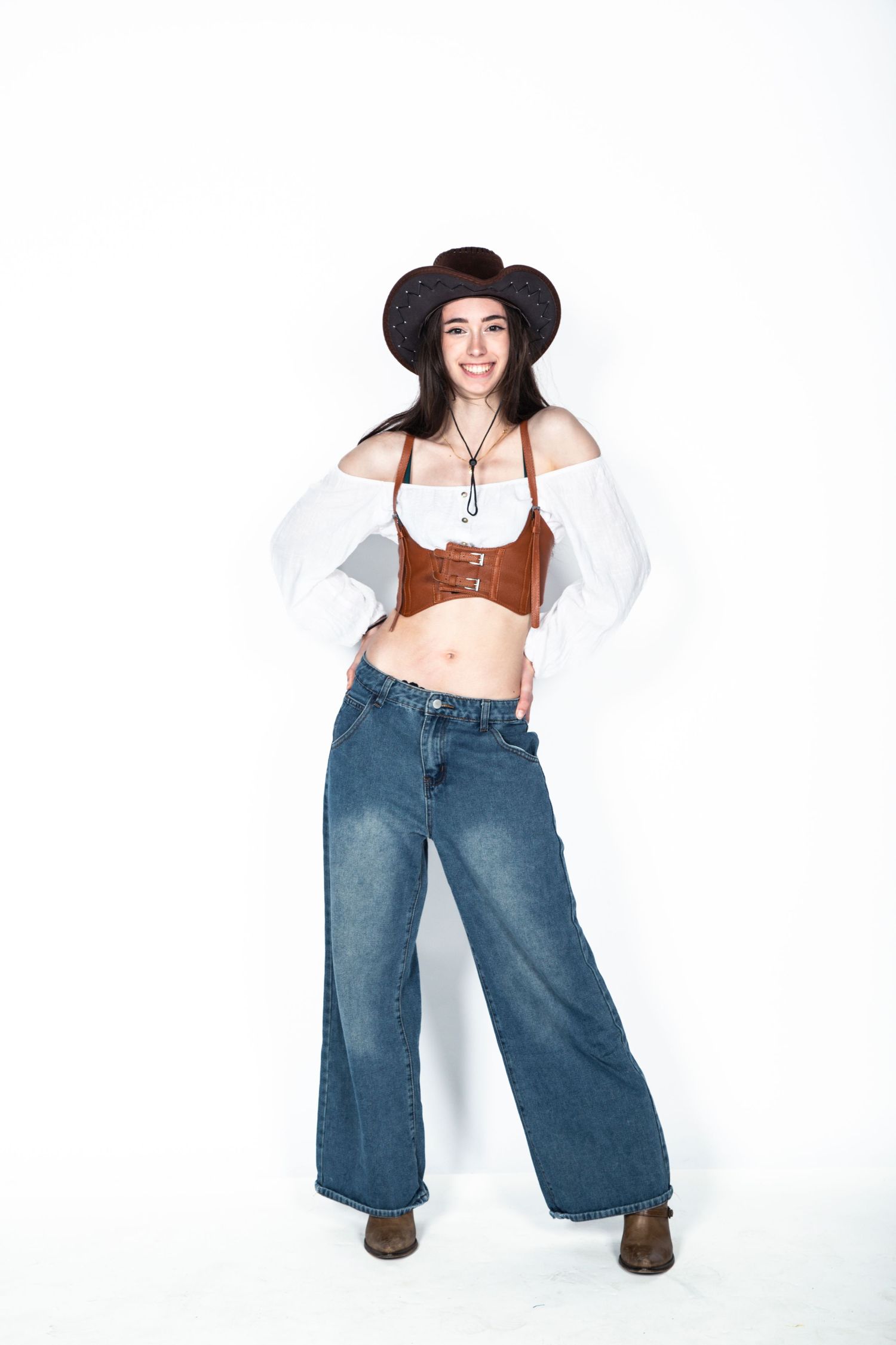 Model wearing brown crop top and wide leg jeans poses in multiple dynamic stances against white background.