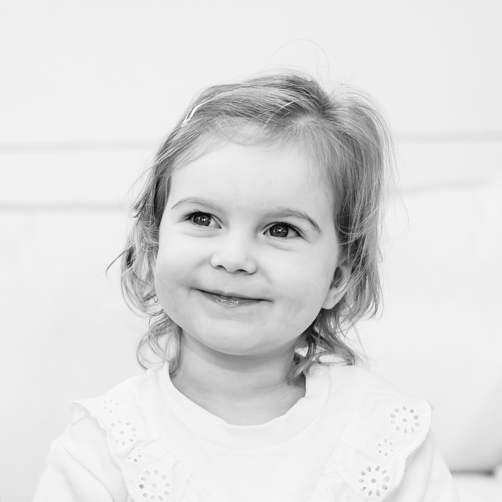 Close-up black and white portraits showing sweet expressions against a white background.