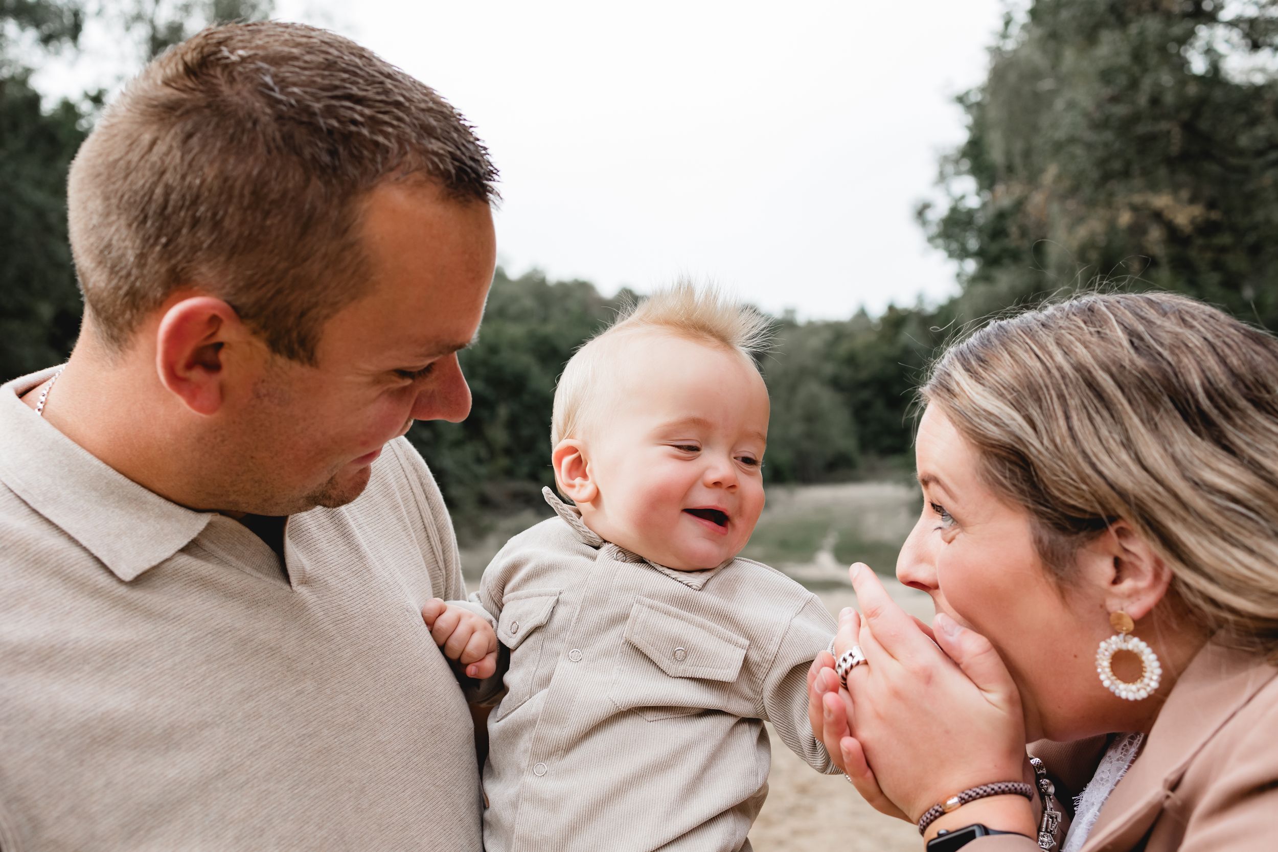 A joyful family photoshoot session outdoors with warm natural lighting and candid expressions.