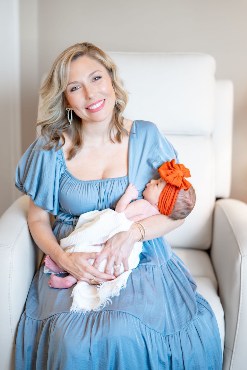A series of photos showing a woman in a blue dress sitting on a couch holding a small baby with orange accents.