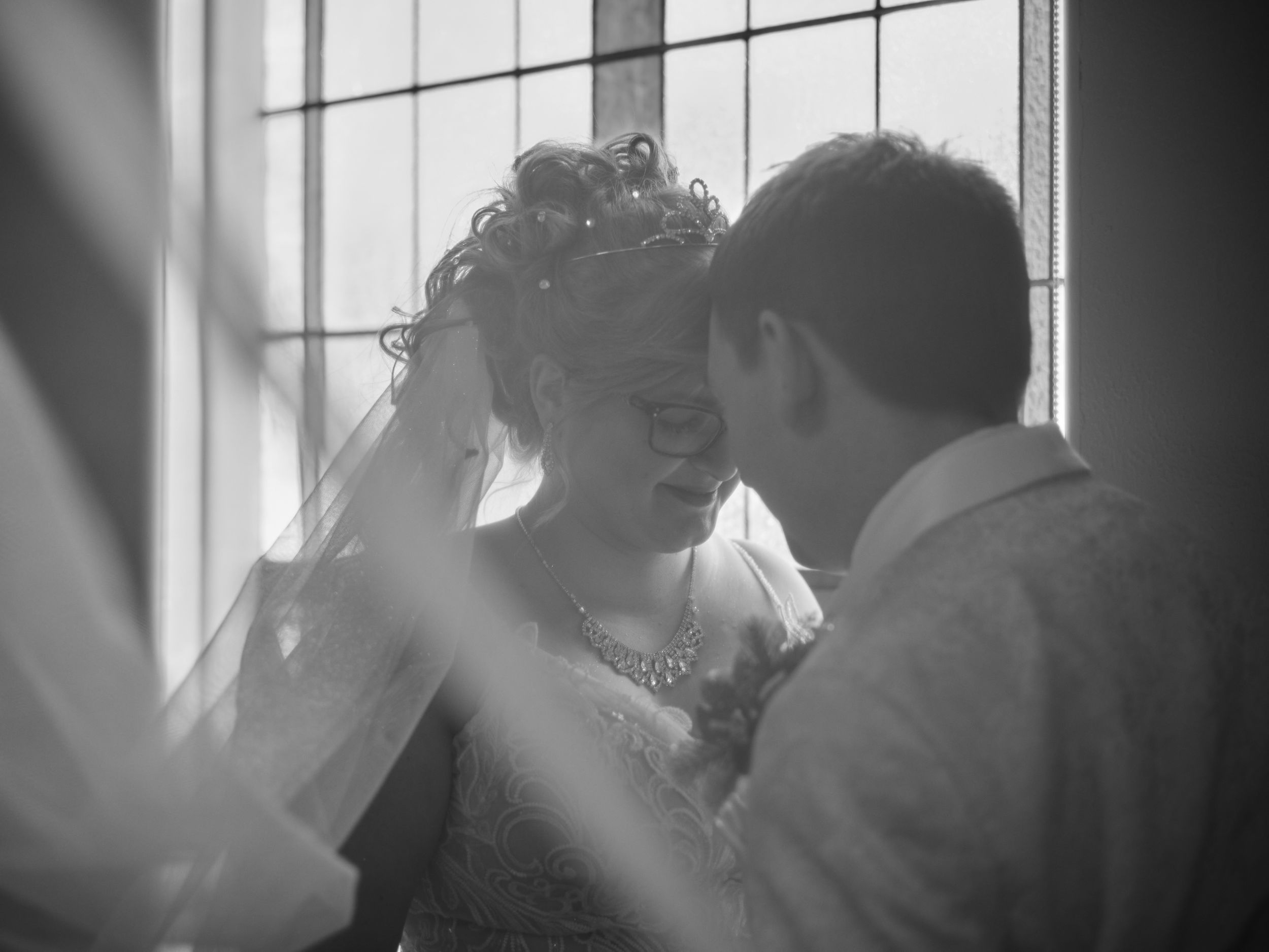 A romantic black and white photo sequence showing a couple embracing and kissing near a window.