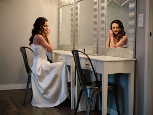 A series of photos showing someone sitting at a vanity mirror in a white dress, captured from different angles.