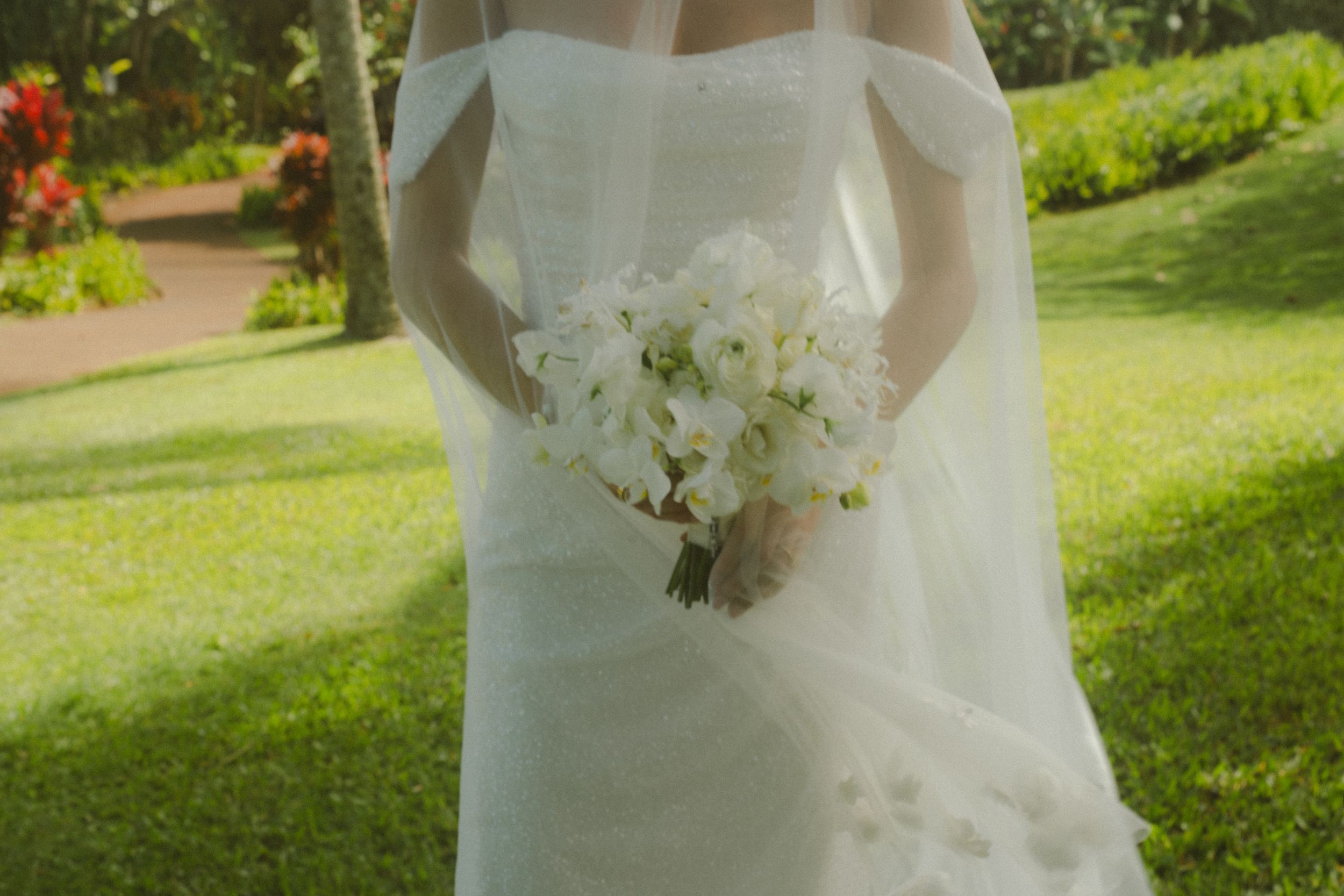bride posing in front of tree at kauai wedding by Kauai Wedding Photographer