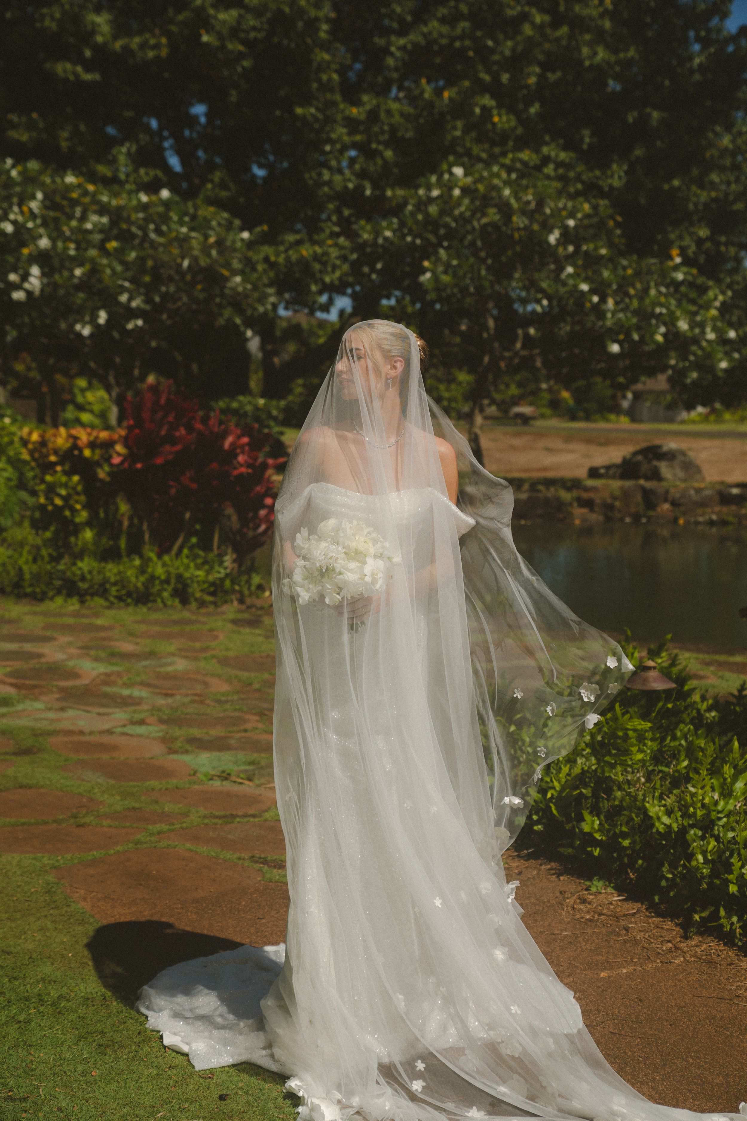 bride posing in front of tree at kauai wedding by Kauai Wedding Photographer