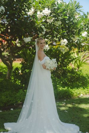 bride posing in front of tree at kauai wedding by Kauai Wedding Photographer