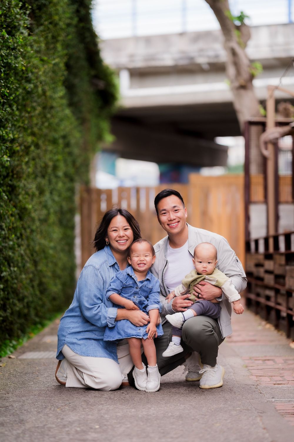 A family sitting together on brick steps outdoors wearing coordinated blue and white outfits.