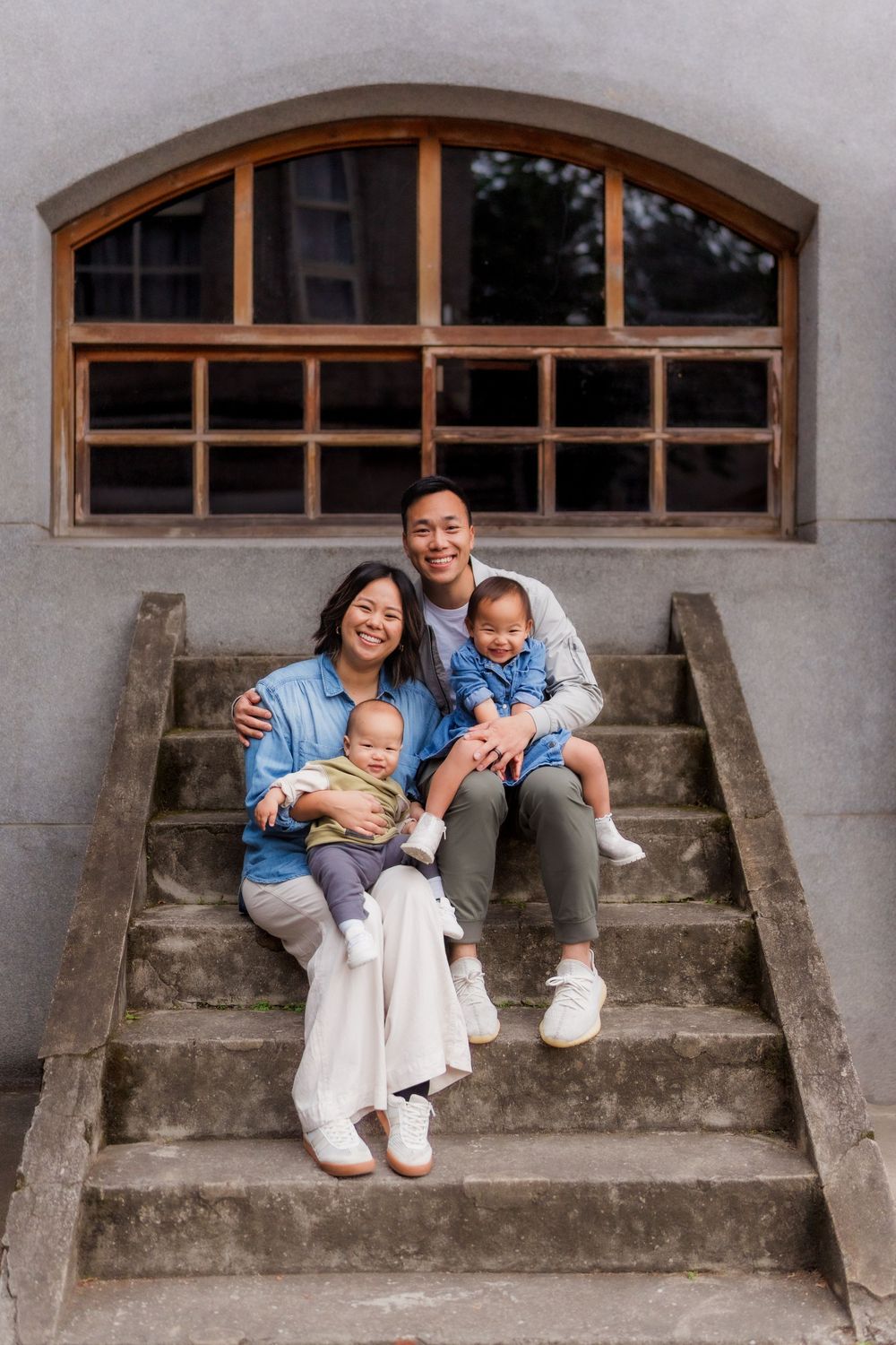 A series of candid family moments captured on concrete steps with arched windows in the background.