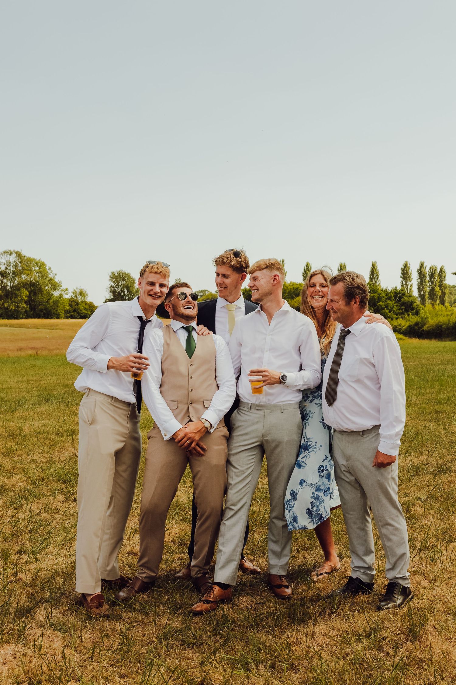 Wedding guests mingling and enjoying the celebration on a sunlit field.