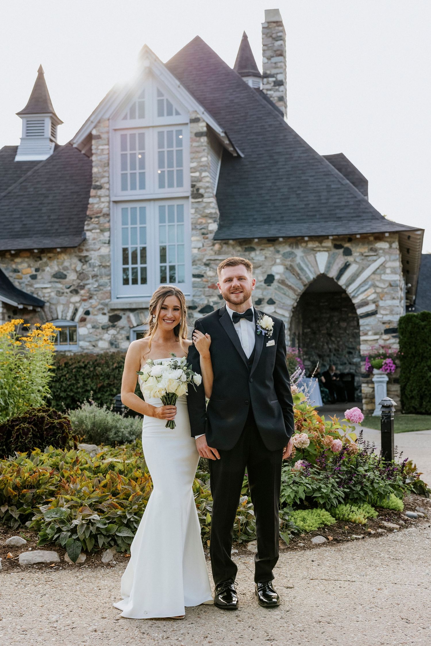 a wedding couple standing in front of a castle on their wedding day