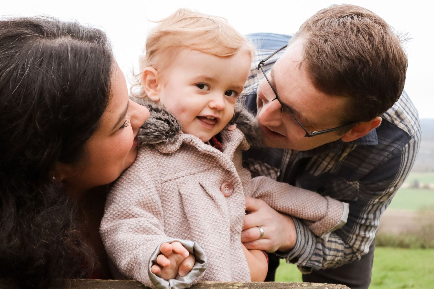 Candid family moments captured outdoors showing affection and laughter.