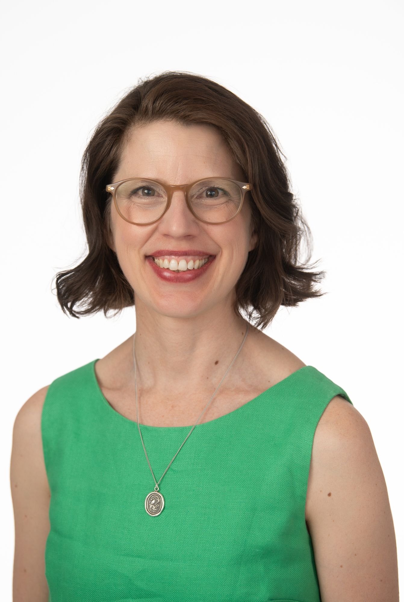 Professional headshots of a person in a bright green sleeveless dress against white background.