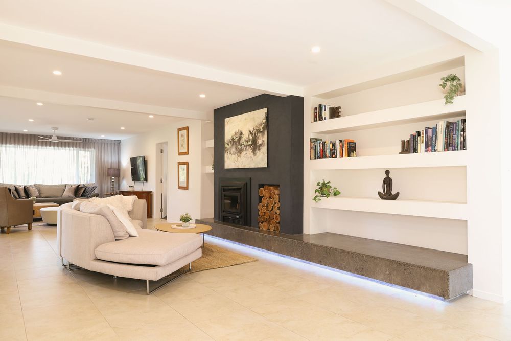 Modern minimalist bedroom interior with floating platform bed, white walls, and sleek built-in storage solutions.