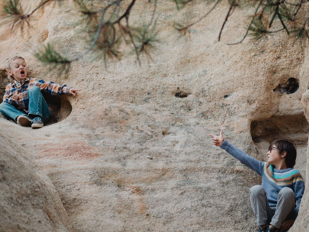 Rock climber scaling a challenging limestone cliff face using chalk and proper climbing technique.