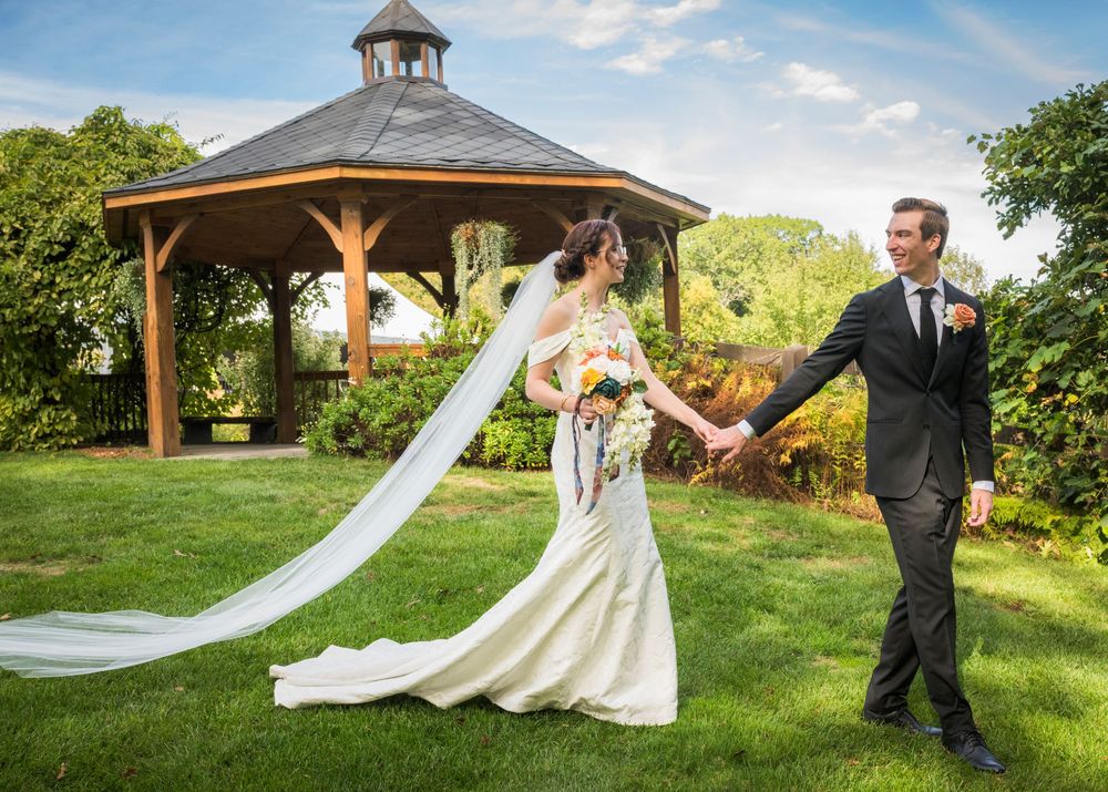 A flowing veil catches the breeze in a romantic outdoor garden wedding photoshoot.