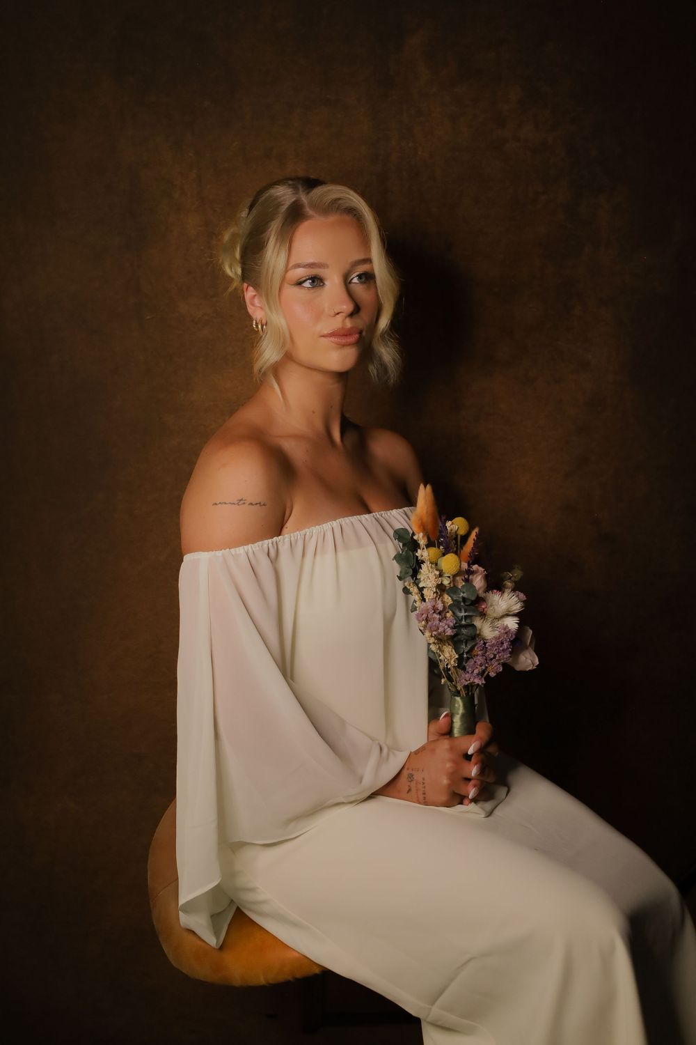 A series of artistic portraits featuring a woman in a white off-shoulder dress holding colorful flowers against a dark backdrop.