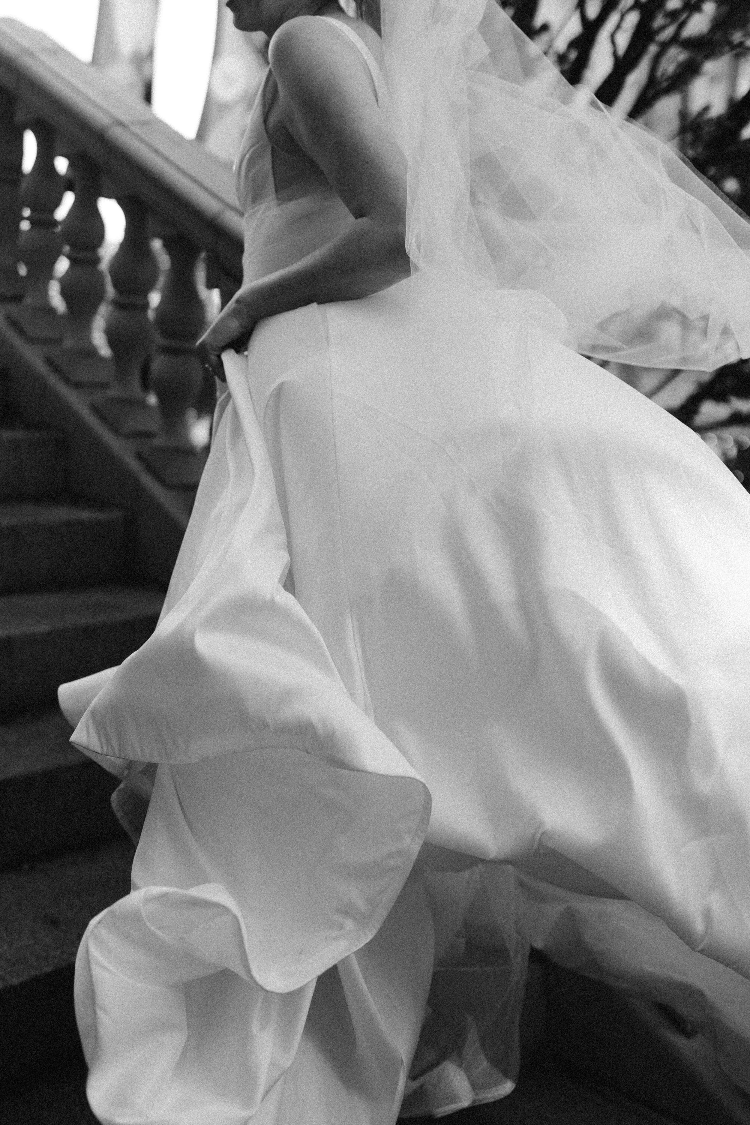 Close-up details of flowing white wedding dress fabric in black and white.