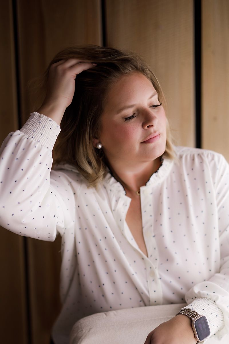 A person in a white polka dot blouse poses gracefully in a series of connected artistic portrait photographs.