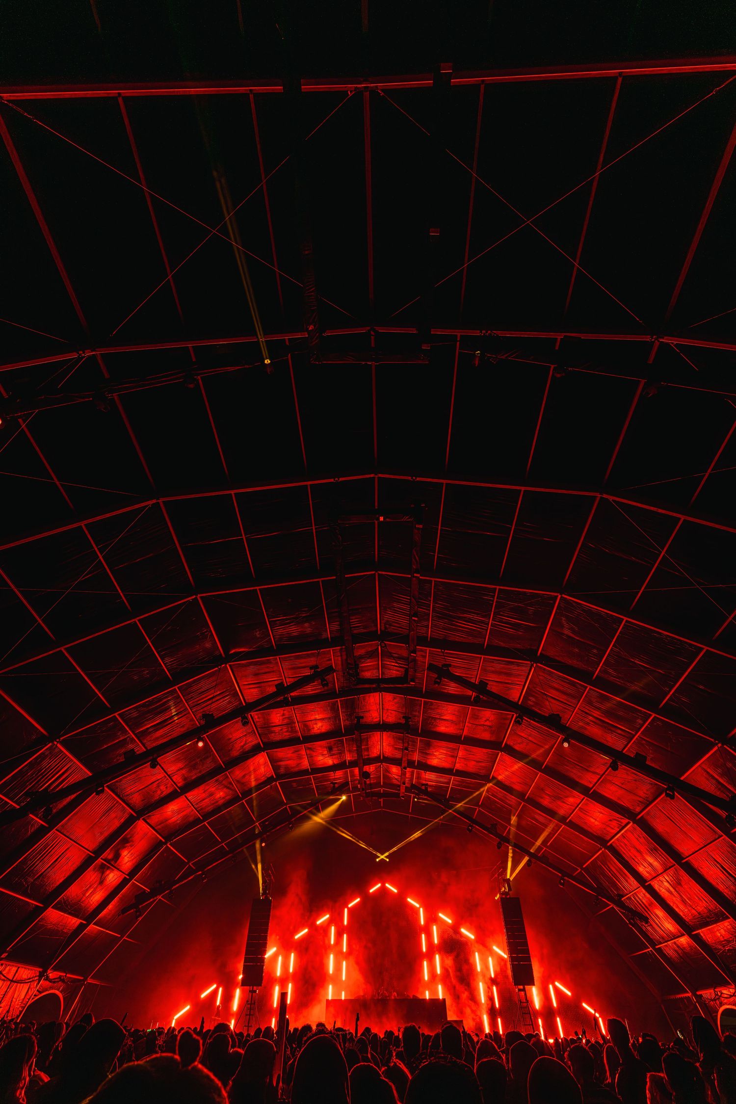 Sequence of red glowing arches in dark tunnel creates dramatic lighting effect and perspective.