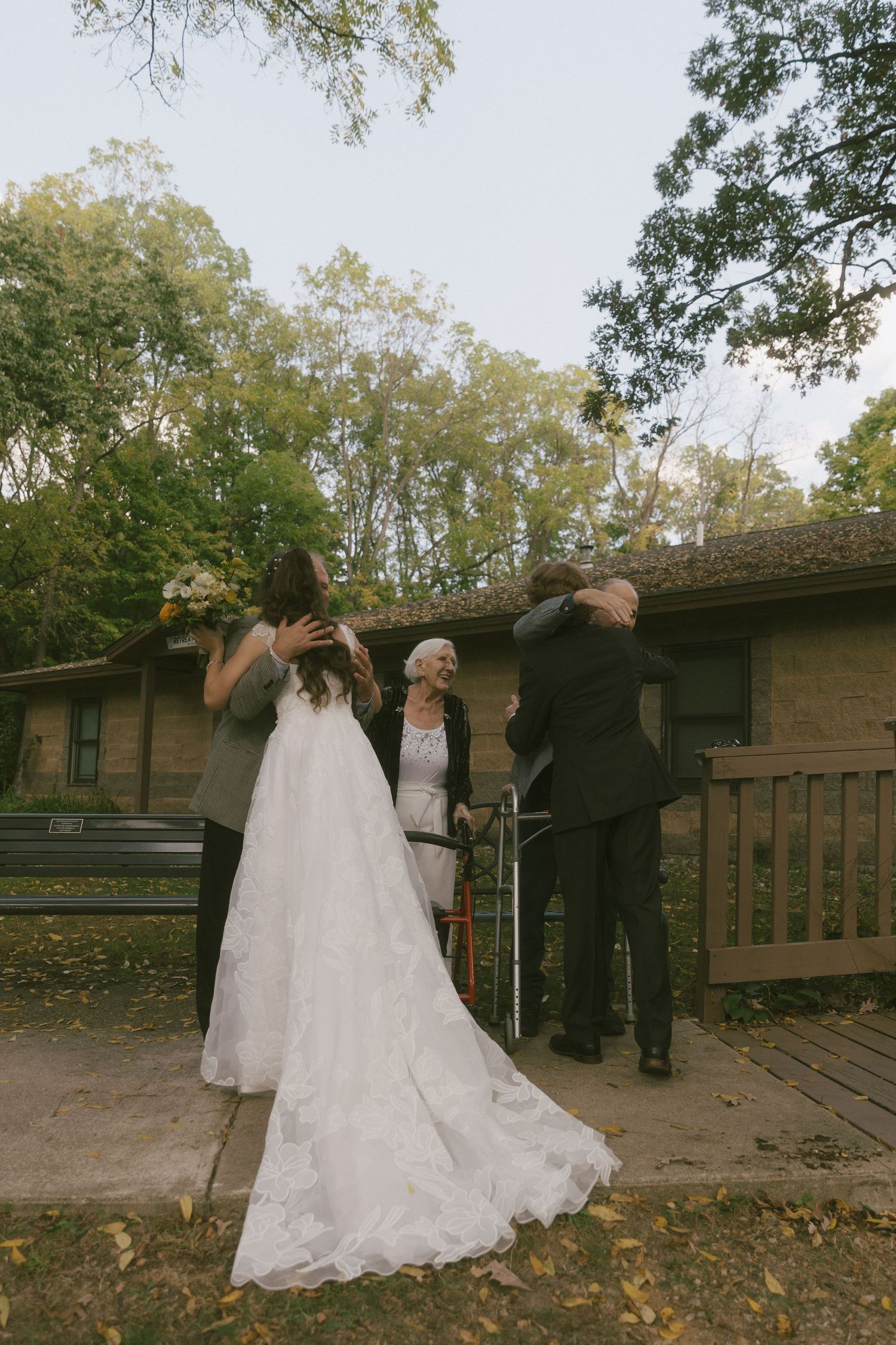 A romantic first look moment between newlyweds on a wooden deck surrounded by autumn trees.