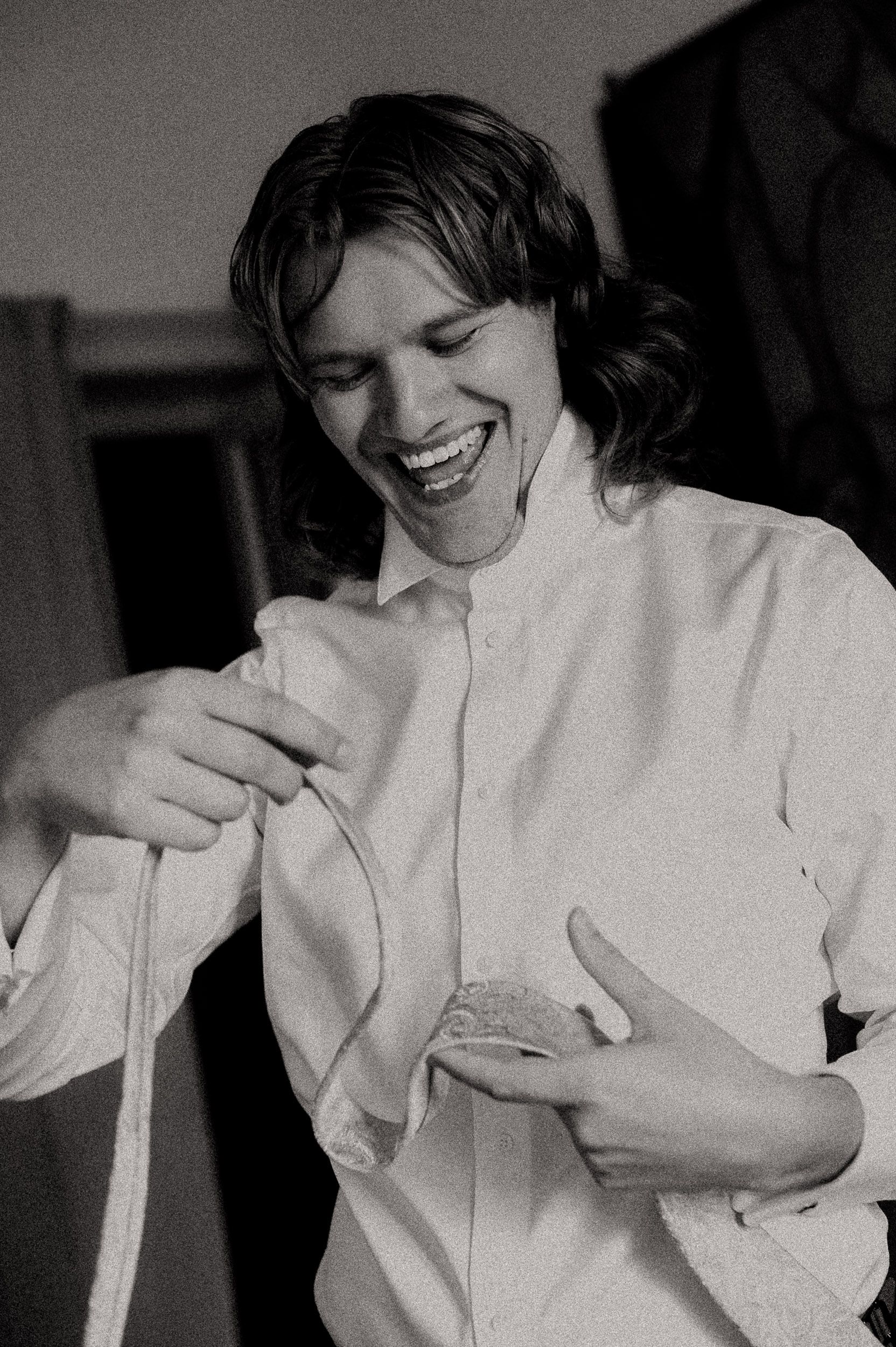 A series of black and white photos showing someone in a white shirt laughing and covering their face.