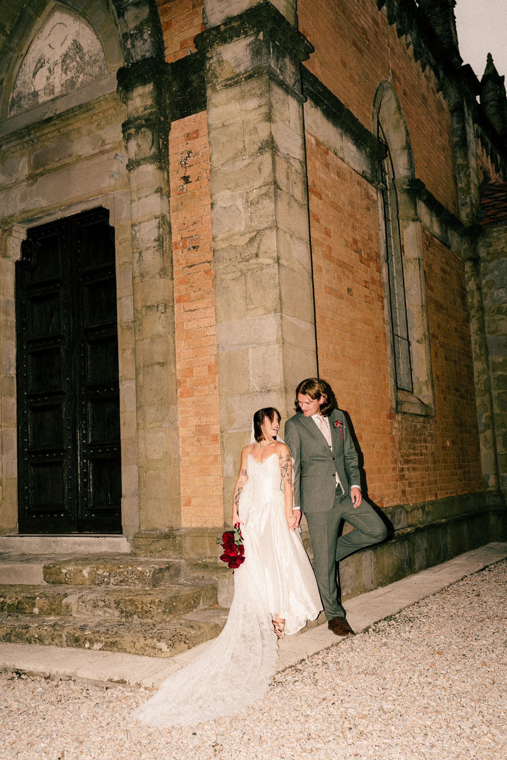 A series of five film photos showing a bride in a white dress walking through a dimly lit stone archway.
