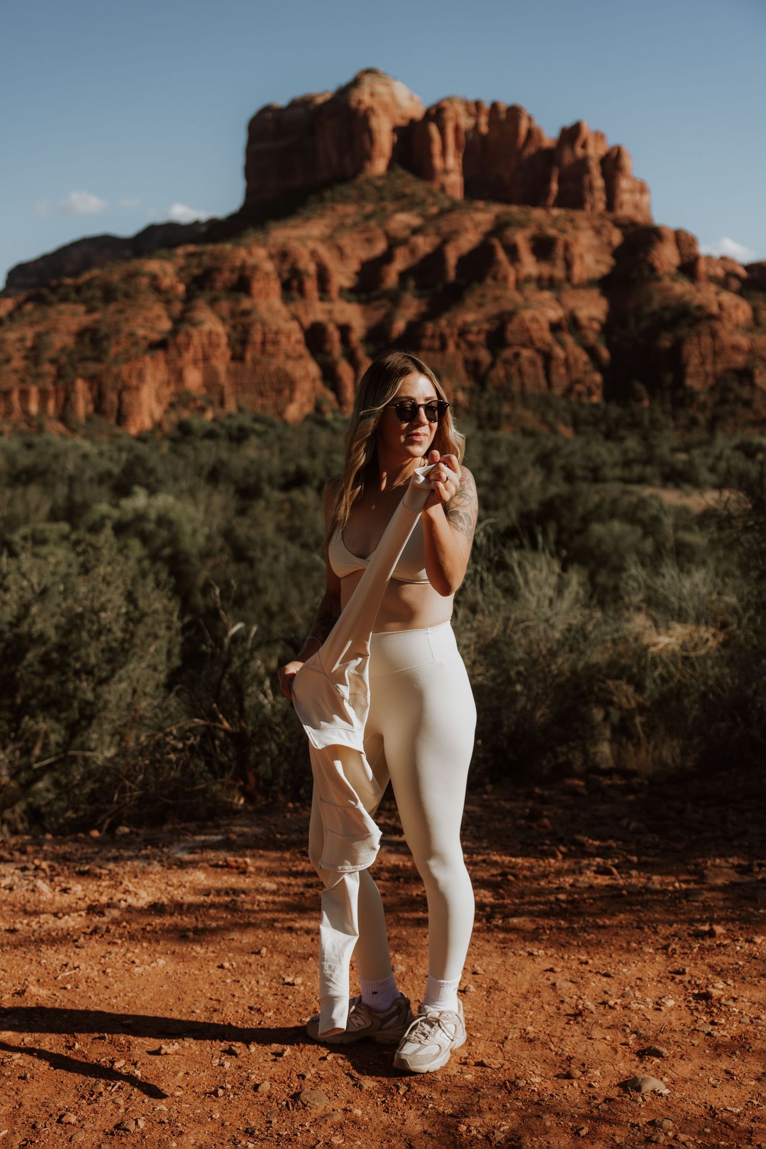 Fitness photoshoot with desert red rocks and blue sky backdrop.