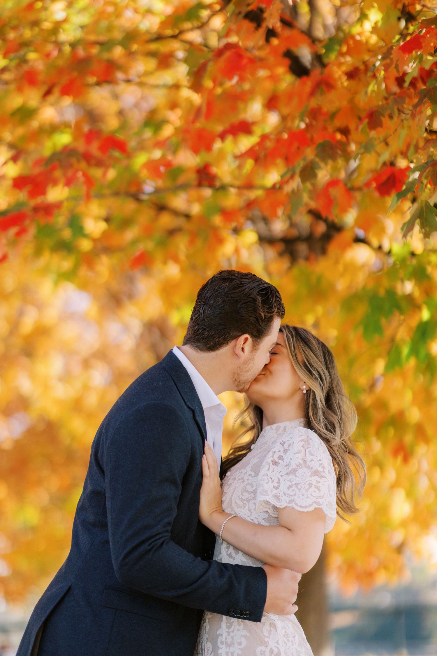 A romantic autumn engagement photo sequence showing a couple kissing under vibrant orange and red fall foliage.