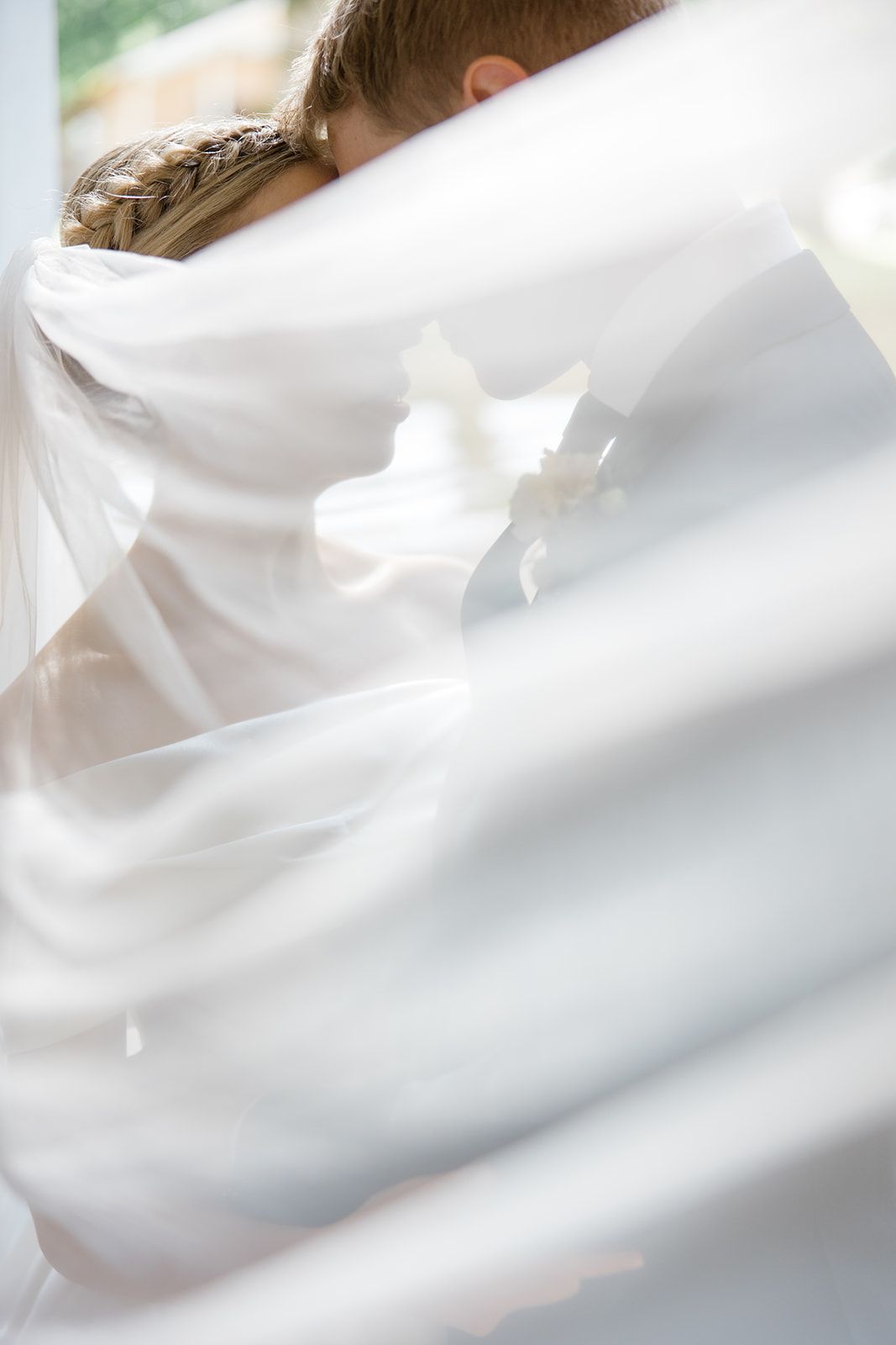 Close-up view of white bedding or fabric creating soft folds and creases in natural light.