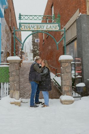 A couple embracing under the Chancery Lane archway in the snow.