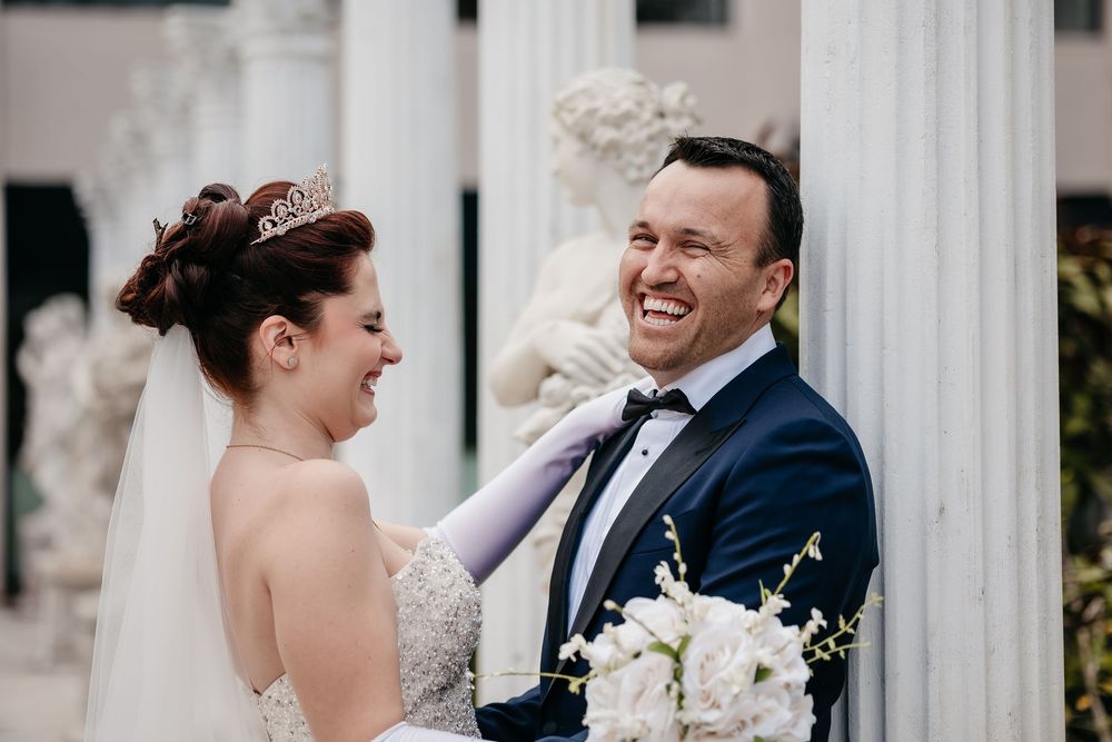 A bride and groom share a joyful moment together during their wedding celebration outdoors.