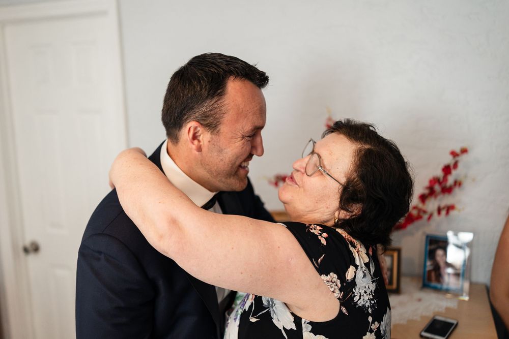 A romantic couple shares a tender moment dancing together in a living room with white walls and holiday decorations.
