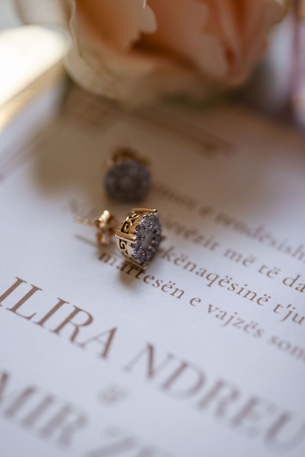 Elegant diamond ring resting on printed text with the word 'LIRA' visible in soft focus.