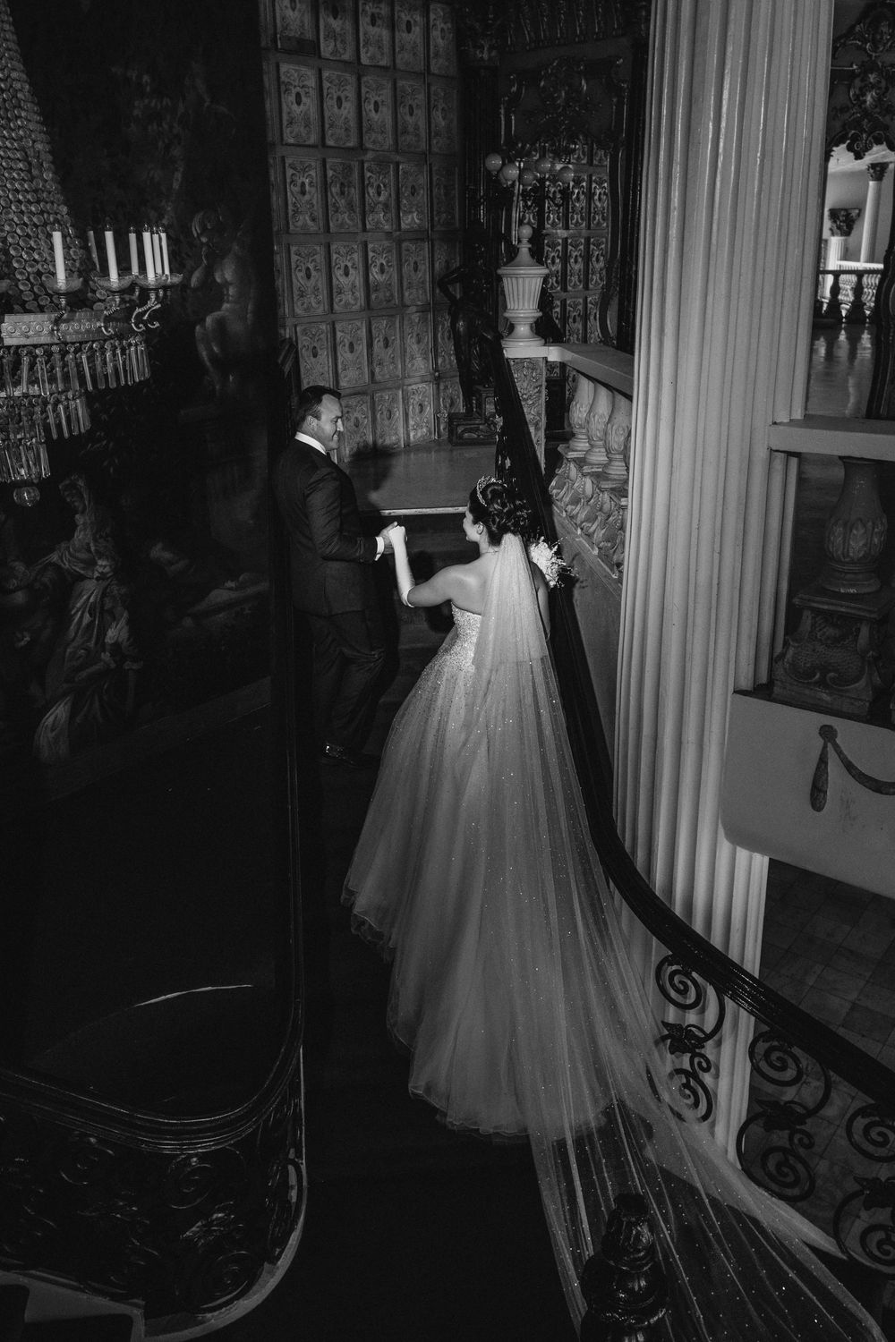 A black and white photo sequence shows a bride in a flowing ballgown descending an ornate staircase in a grand venue.