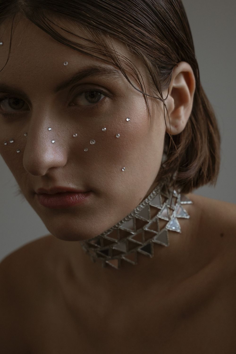 Beauty portrait with crystal embellishments and dramatic side lighting.