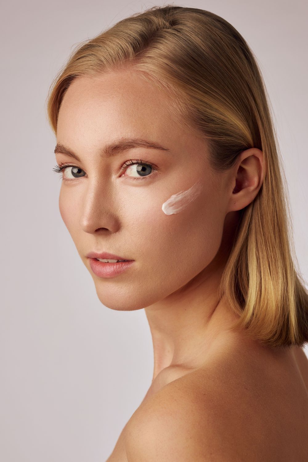 Beauty portrait series with minimal makeup and white face paint accents.