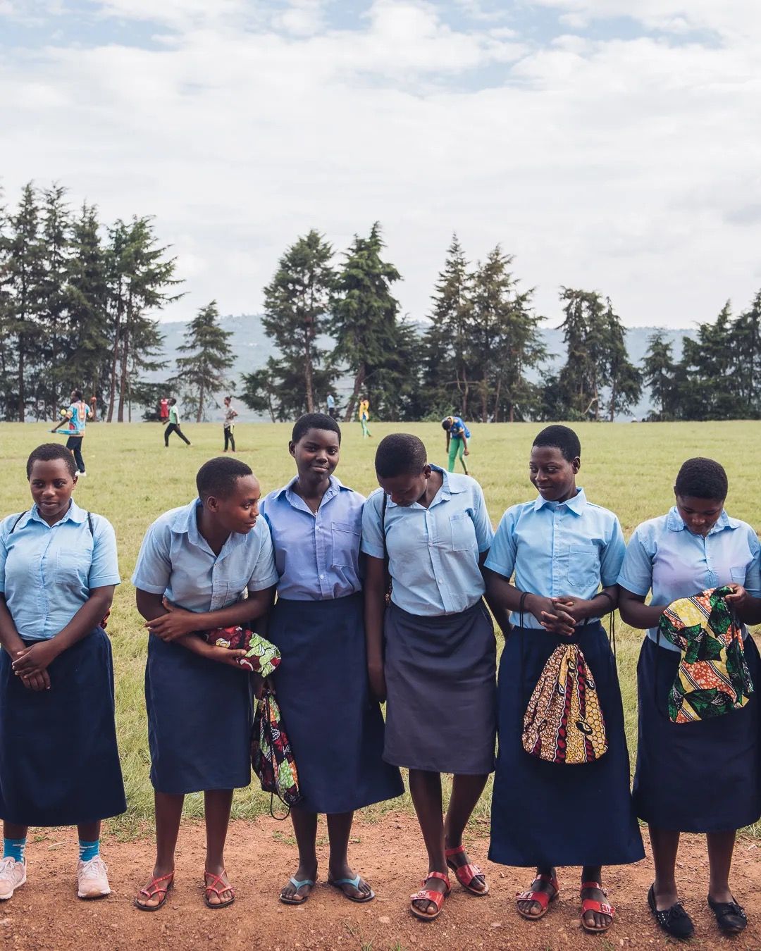 School children stand together outdoors as part of a community education and support initiative.